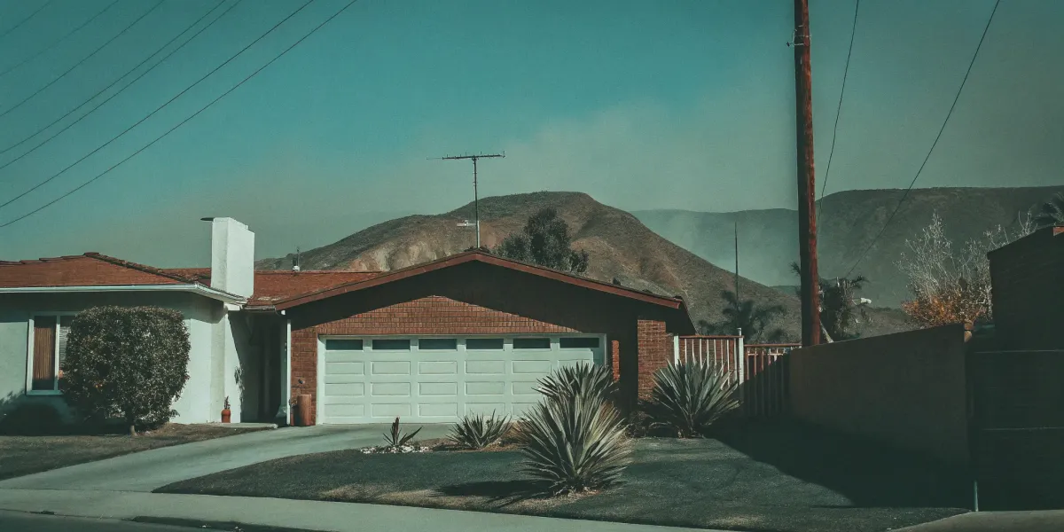 A home in a high fire risk area with dry hills, a challenge for homeowners insurance.