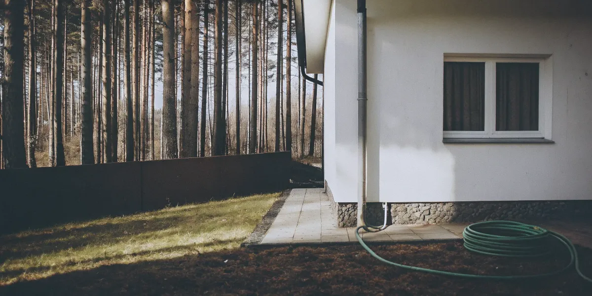 Assessing the immediate ignition zone of a home with a clear yard next to a forest.