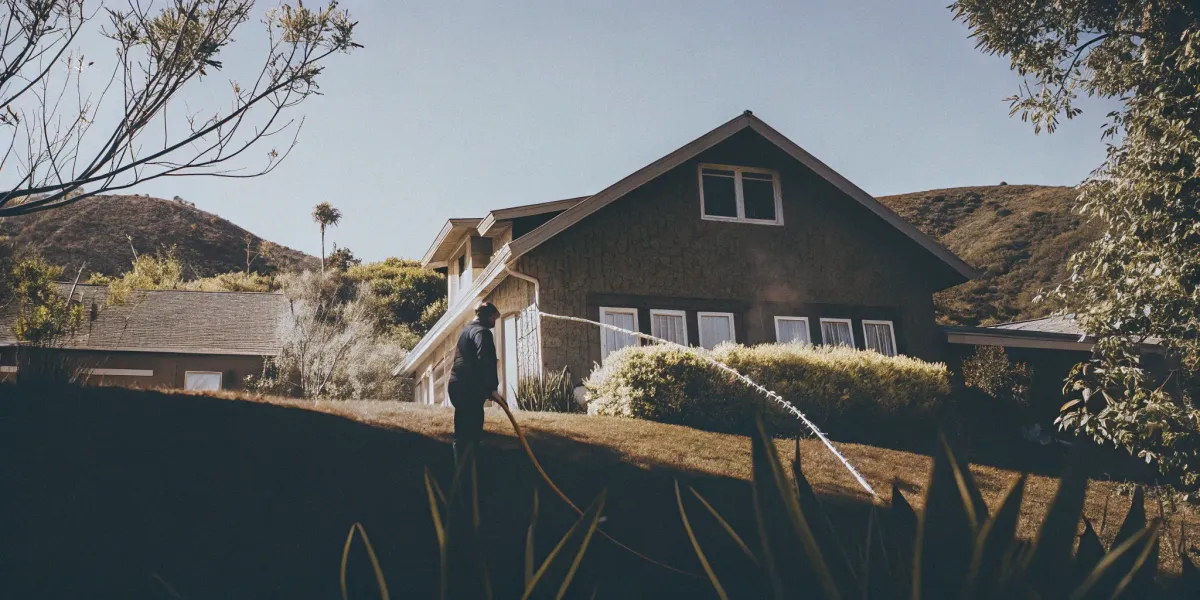 A homeowner creates defensible space for wildfire mitigation and insurance approval.