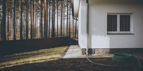 Assessing the immediate ignition zone of a home with a clear yard next to a forest.